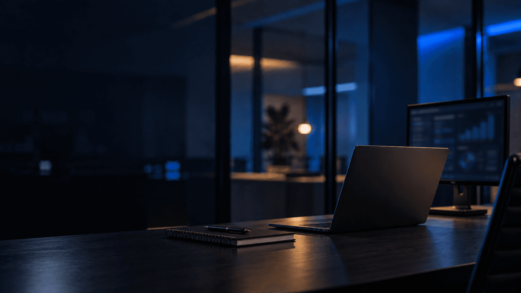 Mesa de trabalho no escritório, com computador e iluminação azul discreta